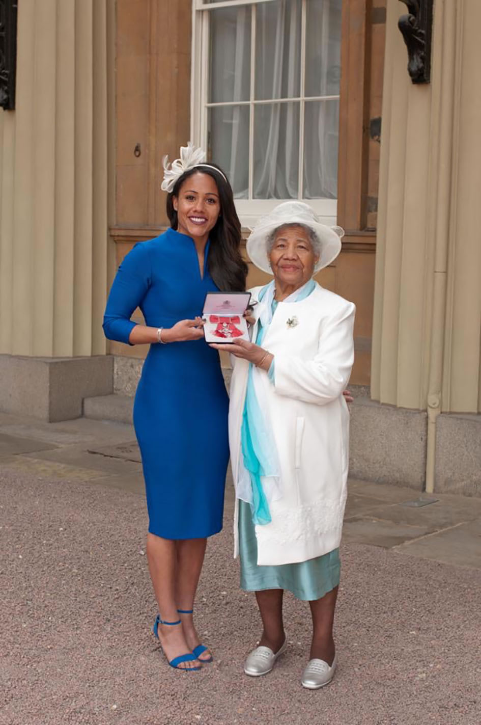 Alex Scott MBE receiving her MBE award, pictured with her grandmother, Philicita
