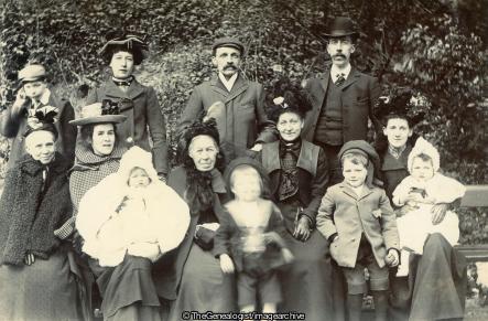 1902 Group of 13 photo man in Derby Hat (1902, Baby, bonnet, boy, cap
, Derby hat, Group, Group Photograph, Man, Straw Hat, Woman)